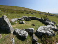 Bronzezeitliche Siedlung Grimspound im Dartmoor mit mehreren gut sichtbaren Rundhäusern und einer ehemals riesigen Mauer um das Dort