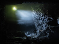 Nebelstimmung in der Cambrian Slate Mine. Durch ein kleines Loch scheint die Sonne in den düsteren Stollen. Die feuchtwarme Aussenluft kondensiert in der Kälte zu Nebel